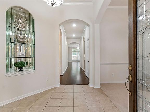 Foyer with glassed and lighted niche.  Dining room to the right.  Office to the left.  New wood floors leading to family room.