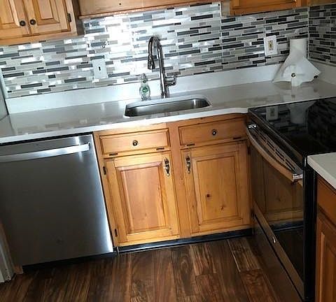 kitchen with back splash and quartz counter top