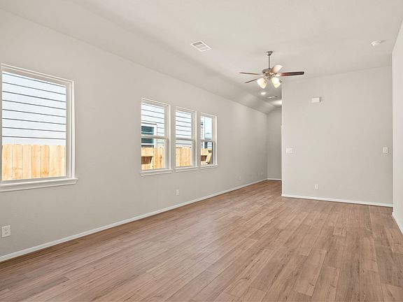 An additional view of the family room featuring a wall of windows allowing plenty of sunshine in, go