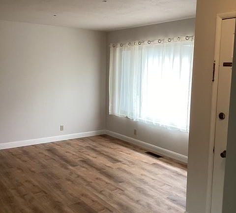 Living Room with Natural Light, Luxury Vinyl Plank flooring. Forced air heat vents.