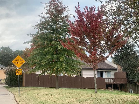 View of deck and privacy fenced patio across Lakewood Village green space.