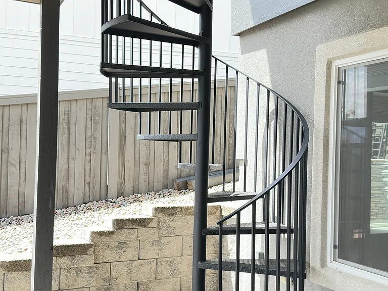 spiral staircase from deck to backyard patio.