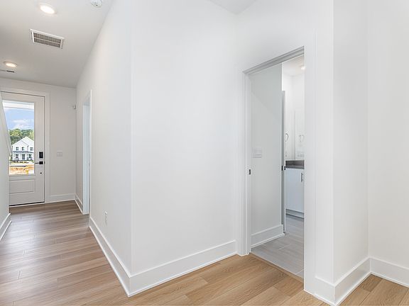 Hallway from 2 car garage toward main floor Bedroom and full bath. Hallway has a huge closet with smart hub for internet connection and security system.