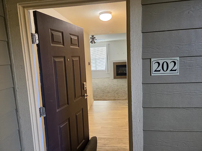 Welcome to your new spacious 2 bedroom, 2 bath home. Unit 202 with view of living room through opened door