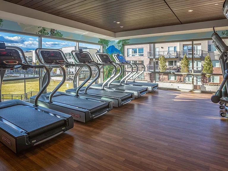 Two-story fitness center with Peloton bikes and yoga studio