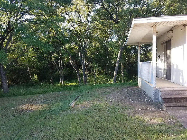 This Master Bedroom has it's own private entrance. It faces the east morning sun and it overlooks the wooded back yard. There is no back alley and a small dry creek runs across the back yard west to east.