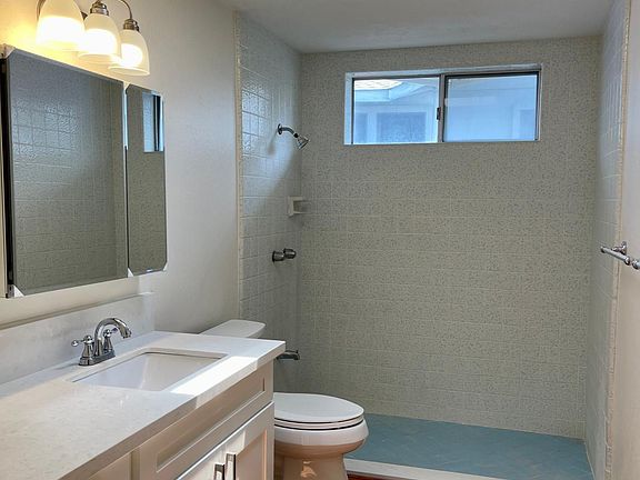Large remodeled bathroom with new vanity cabinet, mirrored-medicine cabinet, toilet, flooring_