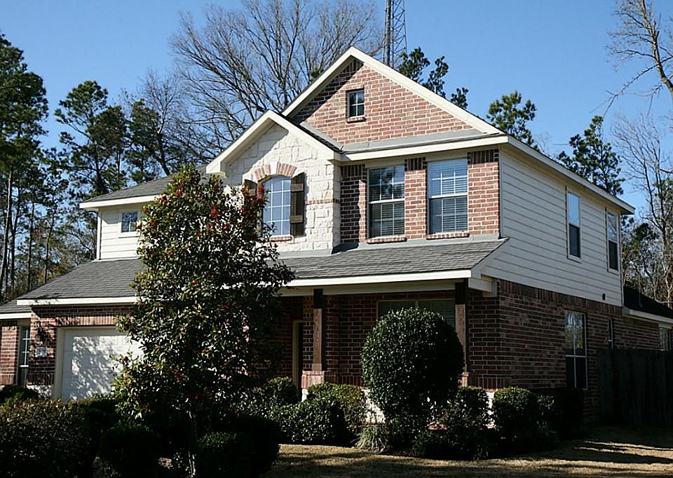 Stone And Wood Accents Along With Coach Lights Create A Stunning Curb Appeal