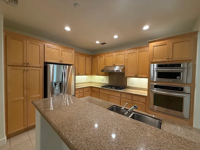Gourmet kitchen is equipped with stainless steel appliances and soft-close cabinetry and granite countertop with a breakfast bar.