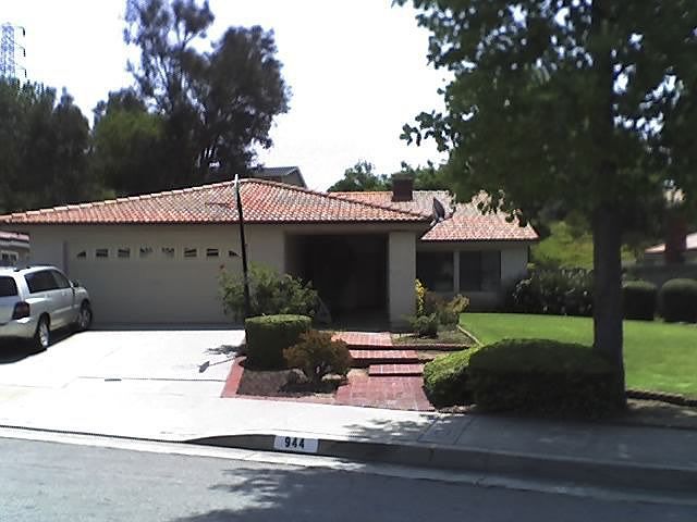 Front of house, with a basketball net.