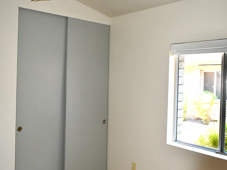 2nd Bedroom has a modern ceiling fan, blackout roller window shade installed Aug 2024. The closet has built-in shelves and rods