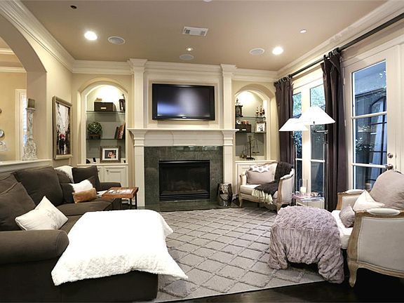 Gorgeous den is open to the kitchen and has gas log fireplace, built-ins, wall of windows/French doo