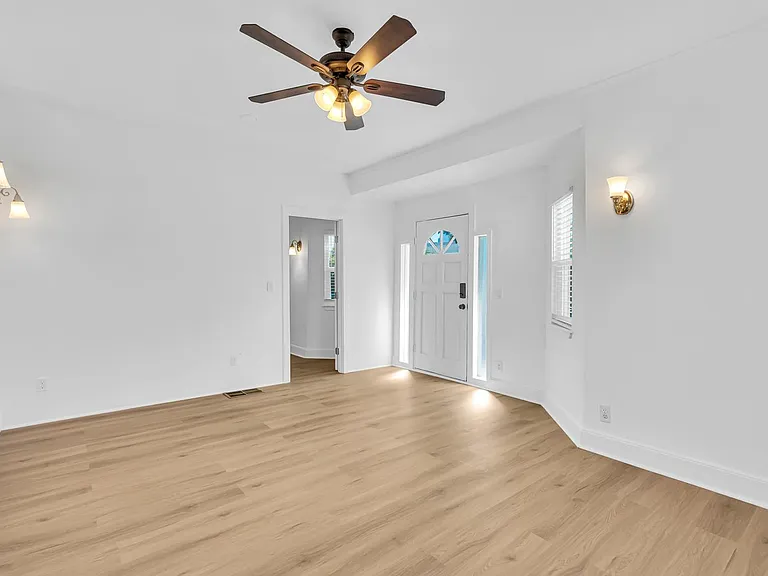 Large living room, showing front door and downstairs bedroom/office.