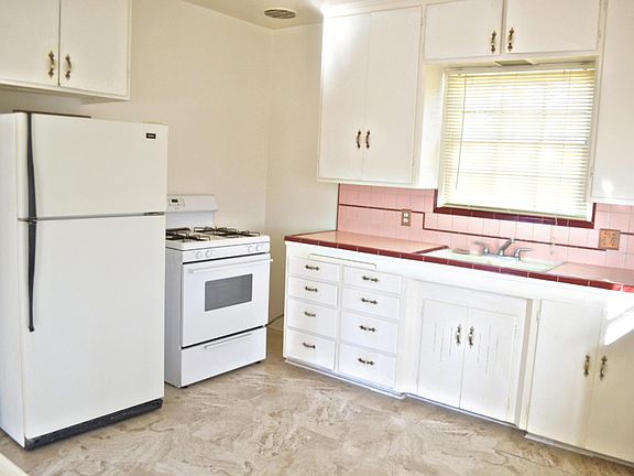 kitchen with new floor, tile count top. Stove and refrigera