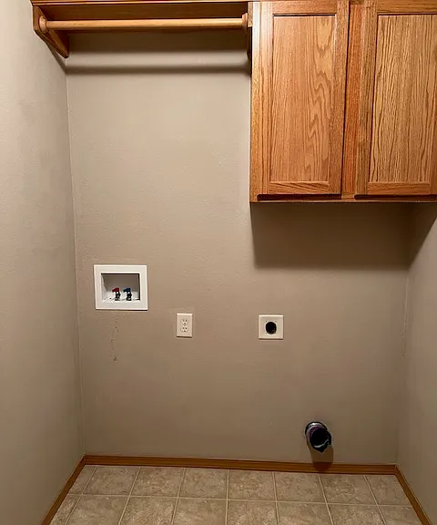 Laundry room with hook-ups, hanging pole and storage shelving