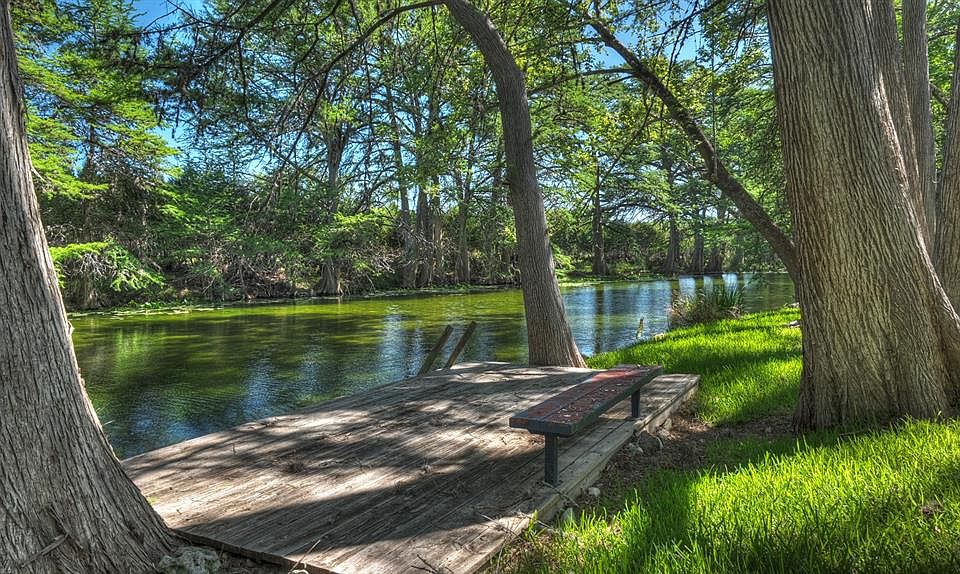 Waterfront property with a wooden dock featuring a built-in bench