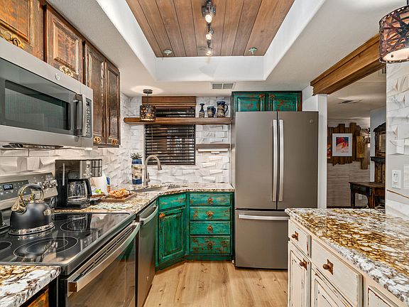 Custom Designer backsplash creates shadows throughout the day. Imported granite. Lots of cabs. Sunny window.