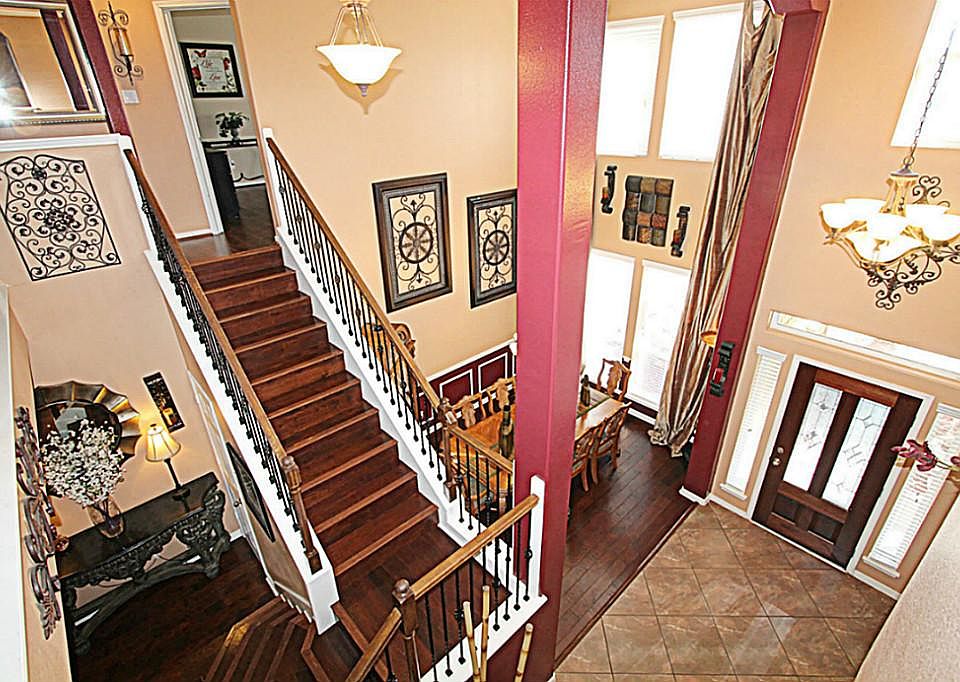 STEP INSIDE TO THE BRIGHT FOYER TO UPGRADED TILE FLOORS, HARDWOOD FLOORS ON STAIRS, WROUGHT IRON SPINDLE STAIR RAILS, DECORATOR COLORS, AND A GREAT OPEN FLOOR PLAN
