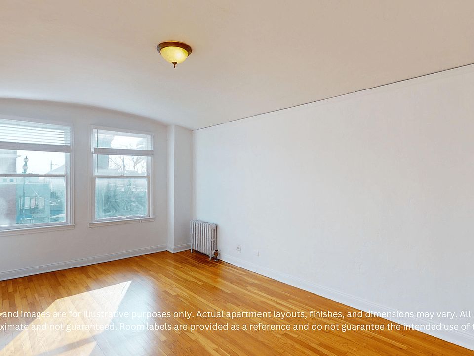 Bright, empty room with hardwood floors, two windows with blinds, a radiator, and a ceiling light.