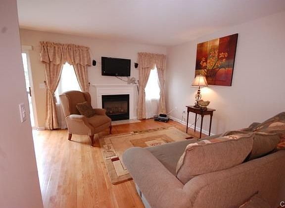 Open floor plan. Living room with hardwood floors and gas firepl