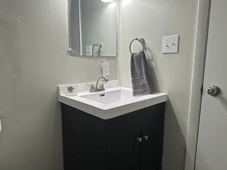 807 Full bath all updated with plank floor, sink / vanity, mirror, lighting, and toilet located off the entry.