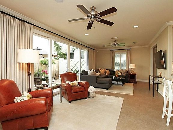 ...plantation shutters, custom linen drapery with black iron rods,16 ft wall of windows with sliding doors, and sleek porcelain tile flooring are rich in style.