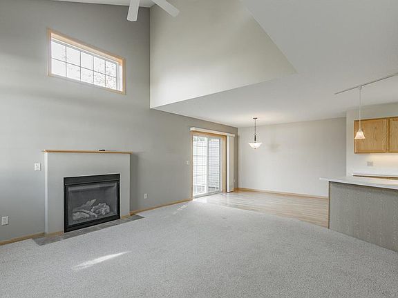 Great room style living room with gas fireplace and ceiling fan