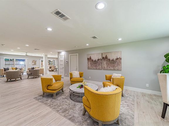 ENTRY: The home features Open Concept space & uses a gray color palette. Wide plank, wood-grain tile in grays & beiges is used throughout the home.