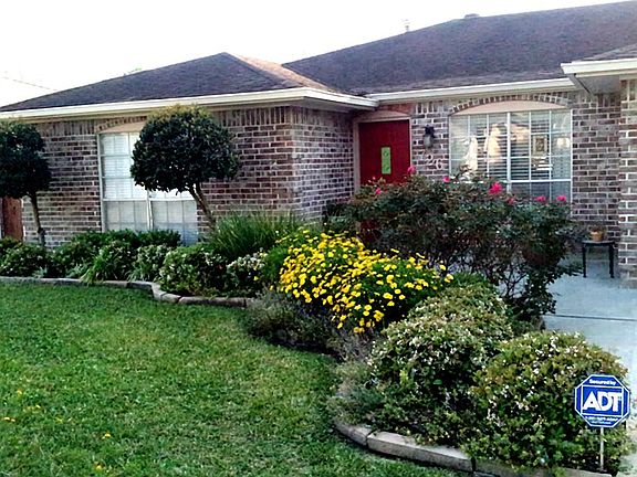 Lush landscaping with small setting area for morning coffee.