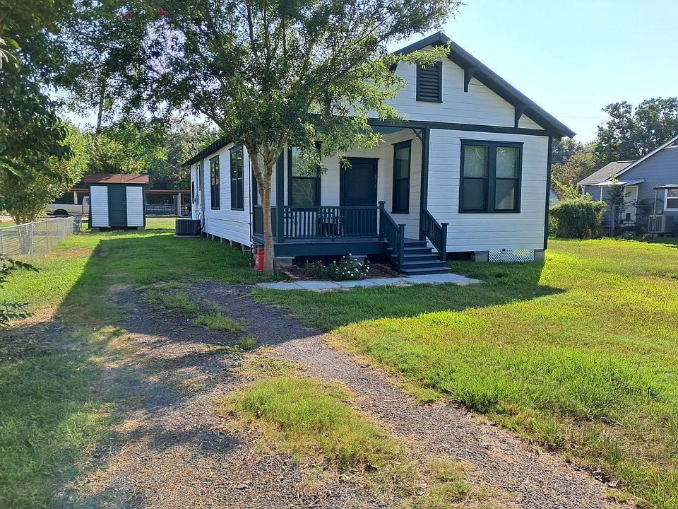 Front view with porch and storage shed in the back