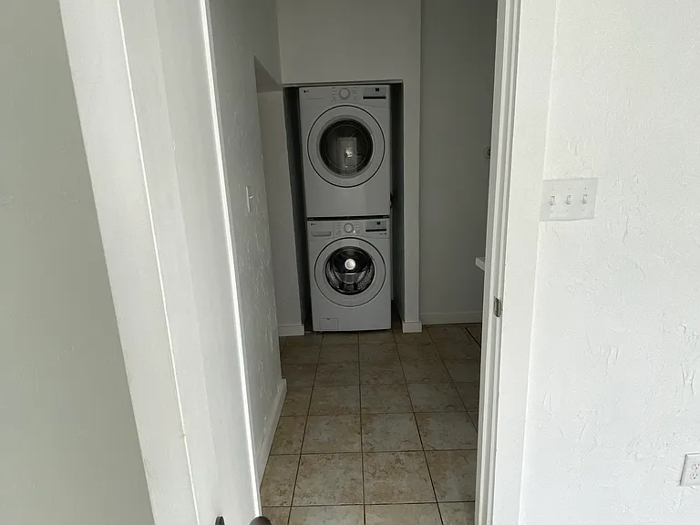 The third bedroom (ideal as an office) opens onto a practical laundry zone complete with washer and dryer, cabinetry and countertop for folding clothes, plus the home's rear entrance