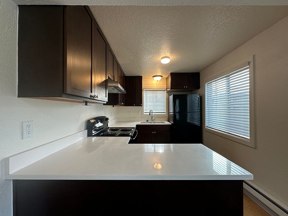 Gleaming kitchen with spacious quartz countertops and newer appliances including dishwasher and in-sink disposal