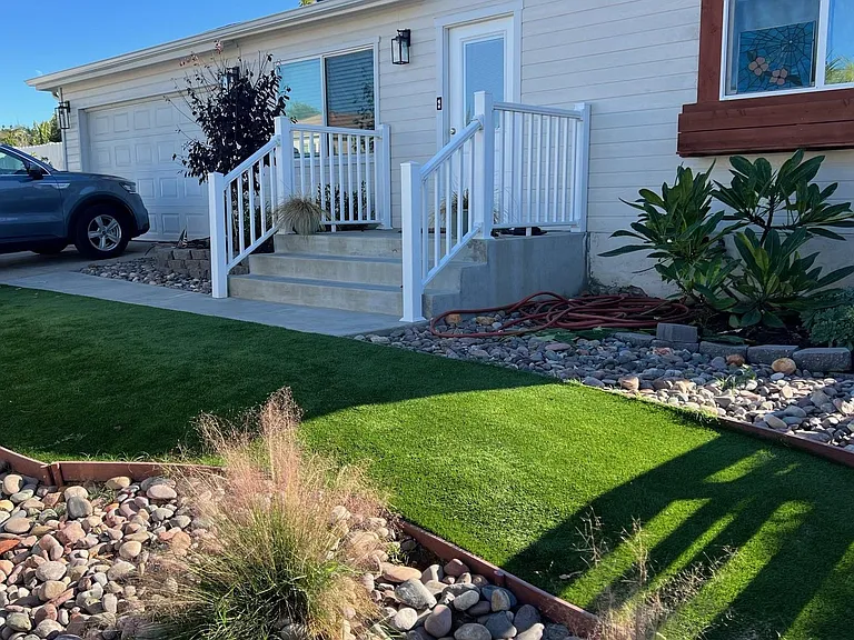 Front yard with low artificial turf.
Parking in driveway and garage!