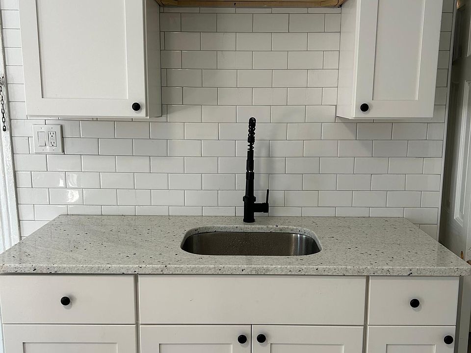 Kitchen cabinets with granite countertop and tile backsplash