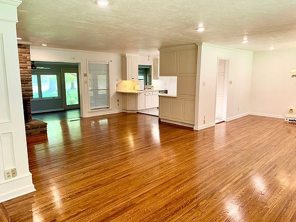 View from the front door looking at the den, kitchen, fireplace, through the FL room and out to the lake.
