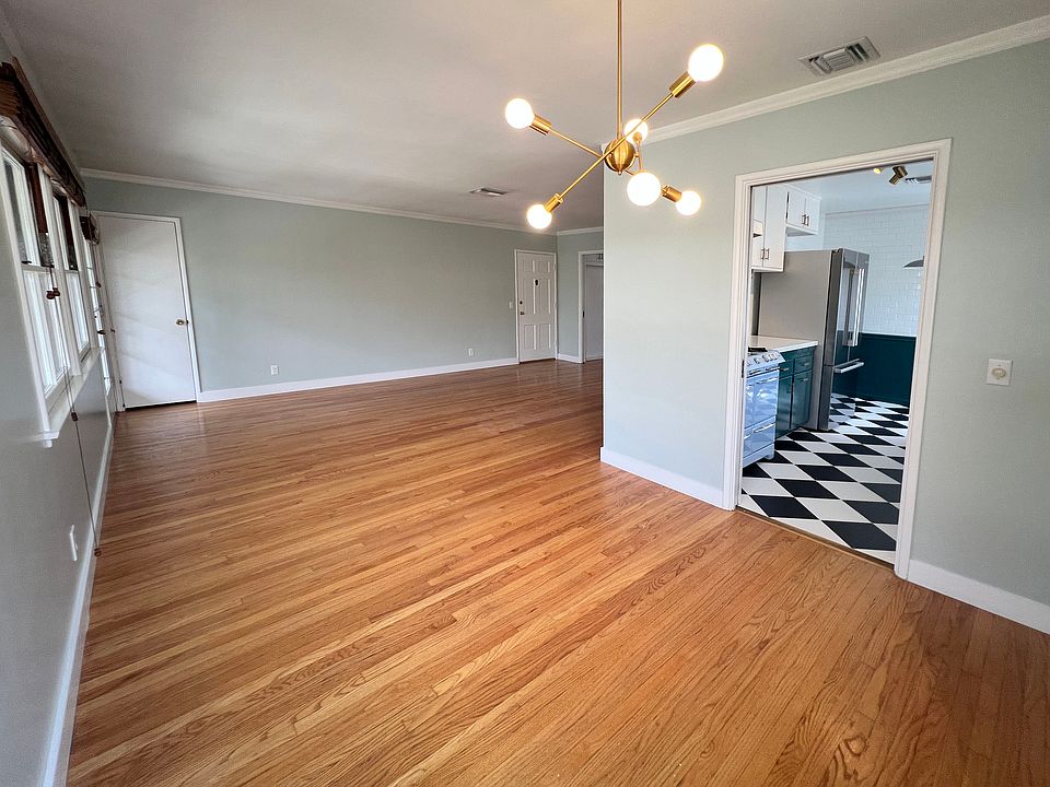 Dining area with "sputnik" style brass chandelier. View into kitchen and living area.