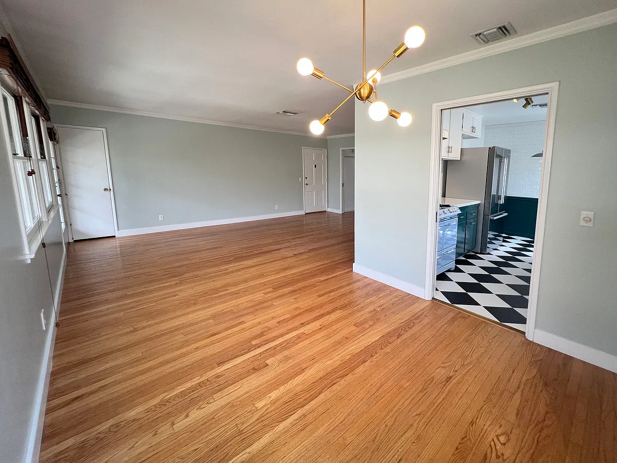 Dining area with "sputnik" style brass chandelier. View into kitchen and living area. - 1327 N Central Ave #F