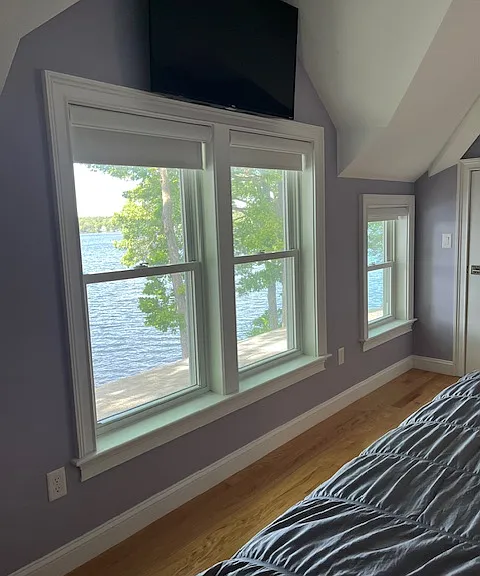 Windows overlooking lake in primary bedroom - second floor. Flat screen TV