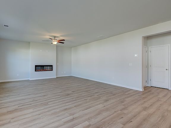 Expansive family room with LVP flooring, natural light, and electric fireplace in the Ridgewood at B