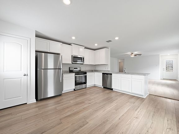 Upgraded kitchen with granite countertops and white cabinetry.