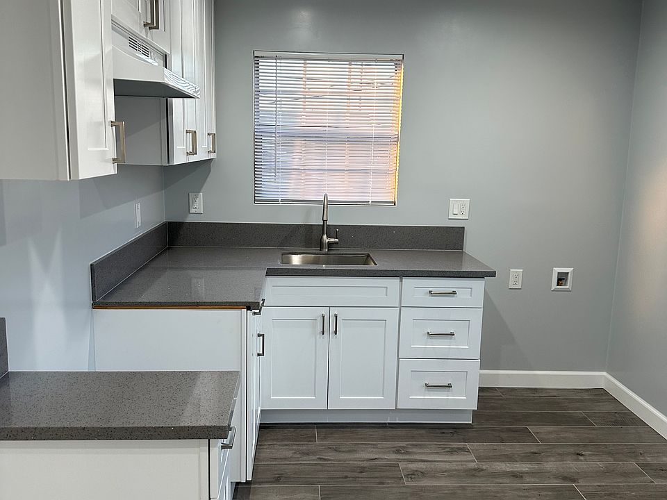 The kitchen cabinets include stainless handles to give it a contemporary look with recess lights and a grey ceramic plank type tile