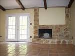 Living room with Saltillo tile Floors, Real Stone Fireplace and French Doors