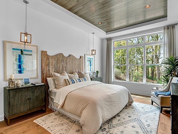 Luxurious first-floor primary bedroom suite with two large walk-in closets
