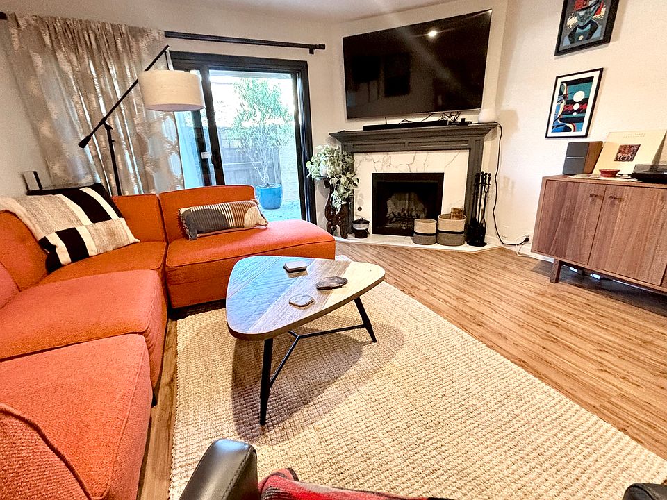 Living room has fireplace and private patio access