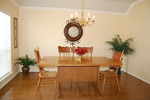 Formal dining room w/ hardwood flooring and crown moulding
