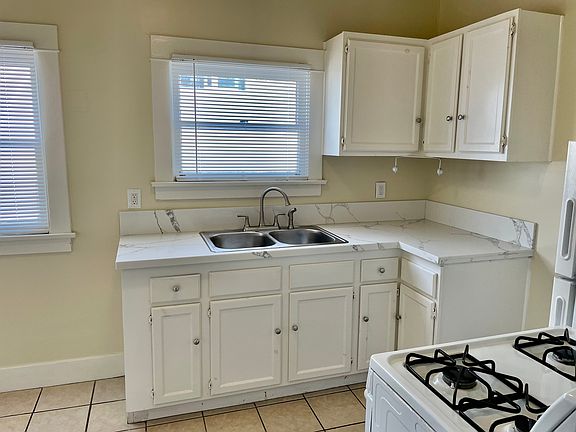 Kitchen with stove, refrigerator, and seating area.