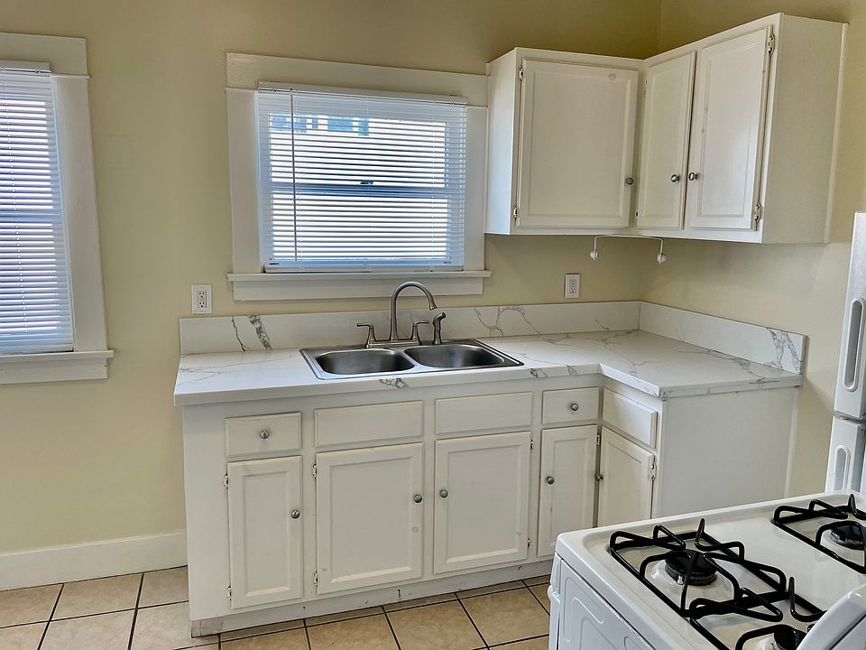 Kitchen with stove, refrigerator, and seating area.