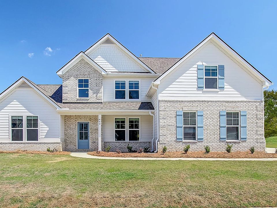 Henry model home with brick and siding exterior, and sideload garage at Kingston in Locust Grove, GA