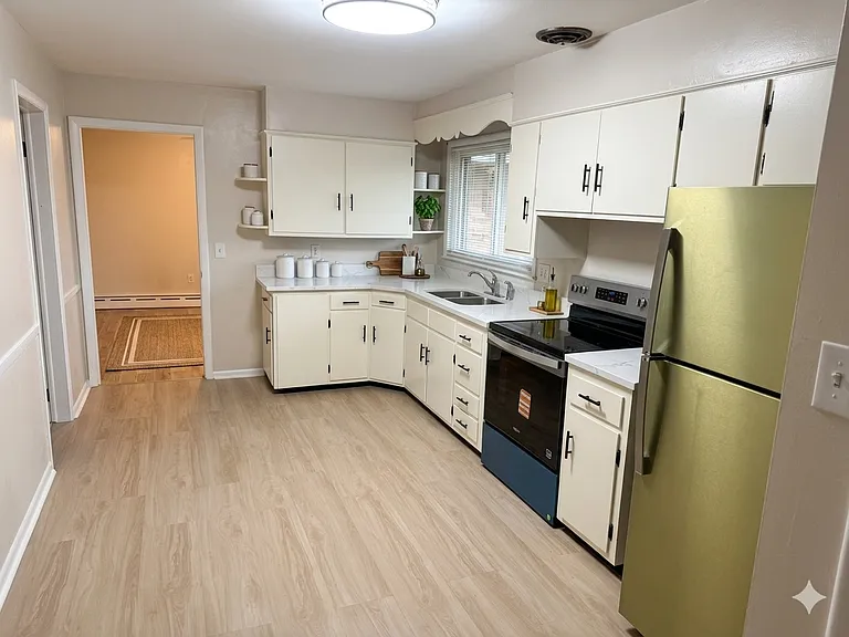 Brand new floor and stainless steel appliances. (fridge is not green it is just the wrapping)