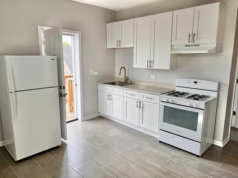 Eat-In Kitchen with New Cabinets, Stone Countertop, Ceramic Tile Flooring, Gas Range and Hood.